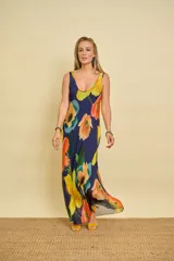 Vestido largo de gasa de seda con estampado floral en tonos amarillos, naranjas y verdes, sin mangas y corte al bies con caída fluida.