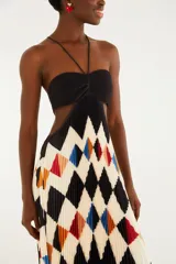 Vestido largo plisado con estampado geométrico de rombos en tonos negro, blanco, azul, rojo y naranja. Cuenta con escote halter con finos tirantes, diseño strapless con fruncido en el centro del busto y aberturas laterales en la cintura.