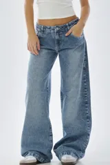 Jean wide leg de tiro bajo, confeccionado en denim de tono azul claro con efecto lavado. Presenta un corte holgado y relajado en las piernas, con cierre frontal y bolsillos clásicos.