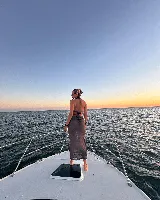 Vestido largo de tejido de punto calado color crema, con escote halter y espalda descubierta.