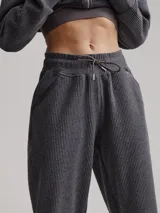 Pantalón de jogging gris con textura acanalada y corte holgado.