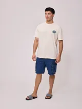 Remera color crema de corte holgado con estampado circular en el pecho.