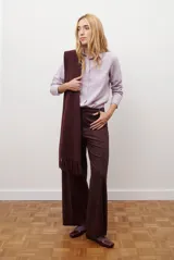 Camisa blanca de manga larga con cuello clásico y botones frontales. Tiene un bolsillo en el pecho con un pequeño logo bordado.