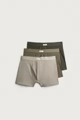 Pack de tres calzoncillos tipo bóxer de tejido elástico con acabado aterciopelado, en tonos neutros gris, marrón y verde oscuro, con cintura elástica.