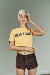 Shorts mini de tiro medio confeccionados en tejido con efecto ante. Presentan trabillas en la cintura, bolsillos delanteros y cierre frontal con cremallera y botón.