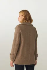 Chaquetón color beige con cuello, abrochadura simple con botón en el cuello, bolsillos ojal y detalle de martingala en mangas. Prenda con forro al tono.