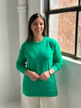 Sweater de punto color verde con diseño de rombos en relieve, cuello redondo y mangas largas con puños ajustados.