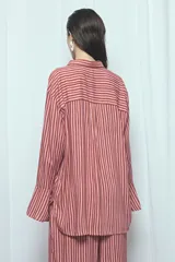Camisa de viscosa con estampado de rayas verticales en tonos rosado y marrón, de corte oversize, con cuello camisero, cierre frontal de botones y mangas largas acampanadas.
