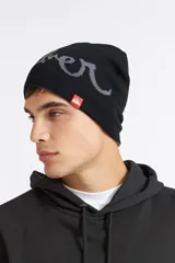 Gorro beanie reversible de punto, color negro con inscripción de la marca en gris en un lado y diseño liso en el otro. Cuenta con una pequeña etiqueta roja con el logo de Quiksilver.