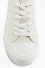 Zapatillas deportivas de lona color crudo, con cordones y suela de goma con diseño.