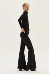 Top negro de manga larga, confeccionado en tela de lurex con calce al cuerpo y escote cuadrado.