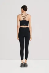 Top deportivo negro de cintura ancha, realizado en tela doble suave y de alta elasticidad. Detalle de breteles cruzados en la espalda.