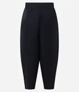 Pantalón de sarga de corte barrel, color negro, con pliegues en la cintura, piernas amplias y botamangas afinadas.