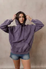 Canguro oversize fucsia con efecto washed, capucha con cordones ajustables al tono, bolsillo frontal tipo canguro y terminaciones de rib en puños y cintura.