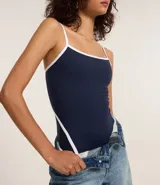 Body azul marino de microfibra con escote redondo, breteles finos, detalles de viés contrastantes en blanco y cierre con broches en la entrepierna.