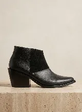 Bota corta de cuero vacuno en color marrón, con diseño de paneles combinados que incluyen textura de reptil en el talón, gamuza en el lateral y cuero liso en la puntera. Presenta un taco cuadrado de 6 cm y suela de caucho antideslizante.