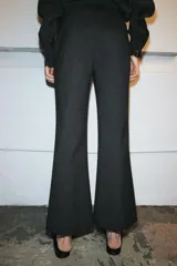 Pantalón de tiro medio con corte cropped flare, confeccionado en tejido con viscosa. Presenta detalle de raya planchada, bolsillos laterales y cierre frontal con cremallera, botón y ganchos metálicos.