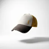 Gorra tipo trucker con visera desgastada en color marrón, panel frontal en color natural y paneles laterales y traseros en color mostaza. Presenta un logo bordado en amarillo en el panel frontal y cuenta con cierre ajustable en la parte posterior.