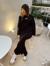 Pantalón Oxford negro de tela scuba con lycra y elástico ancho en la cintura.