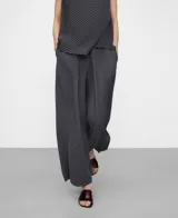 Pantalón gris oscuro de tejido plisado (crinkle), con cintura elástica, bolsillos laterales y diseño de pierna ancha.