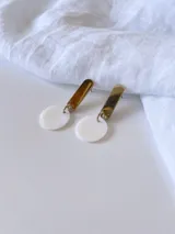 Aros colgantes con base dorada rectangular y dije circular de nácar.