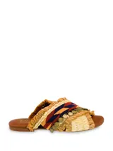 Sandalia plana con tiras cruzadas de rafia y detalle de mostacillas y monedas colgantes.