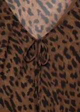 Vestido largo de viscosa con estampado animal print de leopardo, cuello en V con lazo ajustable, mangas largas y forro interior.