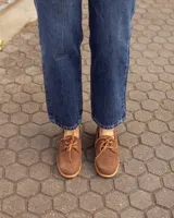 Mocasines estilo náutico de cuero color marrón, con cordones y costuras pespunteadas en el empeine.