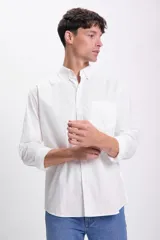 Camisa blanca de manga larga con cuello abotonado y bolsillo en el pecho.