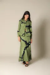 Falda maxi verde con estampado tie-dye en azul oscuro, terminación desflecada en el bajo y lazo ajustable en la cintura.