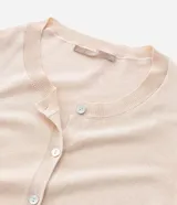 Cardigan de punto color beige, con cuello redondo, cierre frontal abotonado y puños y ruedo acanalados.