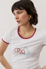 Remera corta gris melange con ribetes amarillos en el cuello y las mangas, y un estampado gráfico abstracto en el pecho.