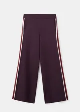 Pantalón de jogging bordó de corte recto y holgado, con bandas laterales en contraste color blanco y bordó. Cuenta con bolsillos laterales y cintura elástica.