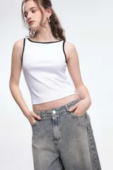Musculosa tipo rib blanca con escote bote, corte al cuerpo y ribetes en contraste de color negro.