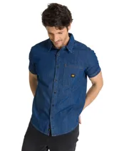Camisa de jean de manga corta, color azul, con cierre frontal de botones, cuello camisero y bolsillo en el pecho con etiqueta de la marca.
