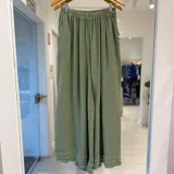 Pantalón ancho color verde seco, de talle alto con cintura elástica fruncida y bolsillos laterales.