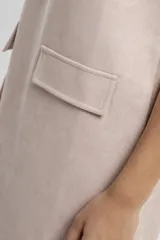 Vestido corto negro con cuello redondo y mangas cortas, con dos bolsillos rectangulares en el frente.