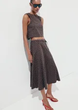 Falda midi evasé de tiro medio, confeccionada en mezcla de lino, con estampado de lunares y detalle de cinturón en la cintura.