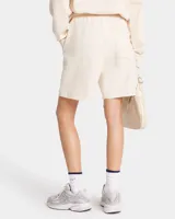 Short color crema de jersey grueso, largo medio, con cintura con cordón, bolsillos delanteros y un bolsillo trasero. Estampado frontal con el logo de la marca.