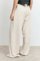 Pantalón de vestir beige de corte palazzo, con pinzas en la cintura y bolsillos laterales.