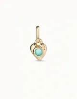Charm en forma de corazón de metal dorado con un cristal de murano turquesa engastado en el centro.