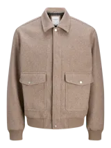 Campera tipo bomber Jack & Jones, color beige, con cuello camisero, cierre frontal con botones a presión y dos bolsillos delanteros con solapa. Presenta puños y ruedo acanalados.