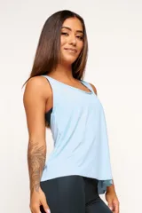 Musculosa deportiva blanca de corte holgado, con espalda estilo nadador y logo pequeño en el ruedo.