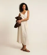 Pollera midi de corte clochard confeccionada en mezcla de viscosa y lino. Presenta cintura elástica con lazo ajustable del mismo tejido, bolsillos laterales y una caída fluida.