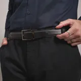 Cinturón reversible de cuero con hebilla metálica rectangular de diseño clásico.