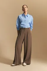 Pantalón ancho color marrón, de silueta moderna y calce cómodo, con diseño limpio y fluido. Presenta cierre frontal con botón y cordones ajustables en la cintura.