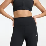 Calza deportiva New Balance de tiro alto, color negro, con tecnología NB DRY de secado rápido y logo de la marca en la pierna.