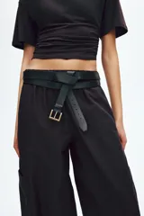 Pantalón cargo de corte holgado en color marrón, confeccionado en mezcla de algodón y nailon. Presenta cintura elástica de talle alto y perneras estilo globo con bolsillos tipo parche a los lados y costuras visibles en la parte delantera.