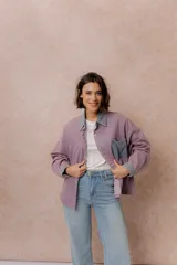 Camisa lila de calce relajado y manga larga, con cuello clásico, puños y bolsillo delantero en denim contrastante. Cierre frontal con broches metálicos.