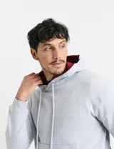 Sweater deportivo con capucha, bolsillo canguro frontal y cordones de ajuste. Presenta un diseño de color azul oscuro con interior de capucha en color verde.